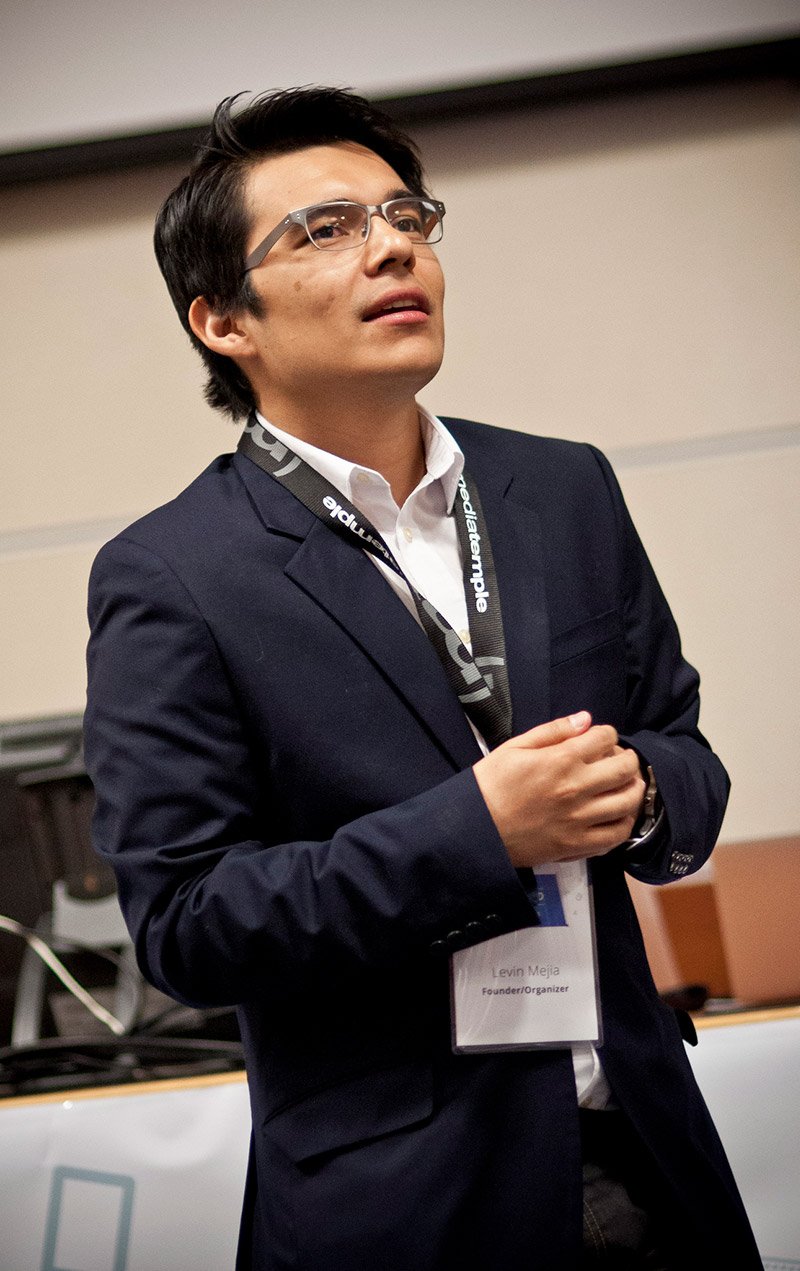 Levin presenting on stage at a design event